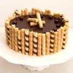 A flourless chocolate birthday cake with wafer cigars.