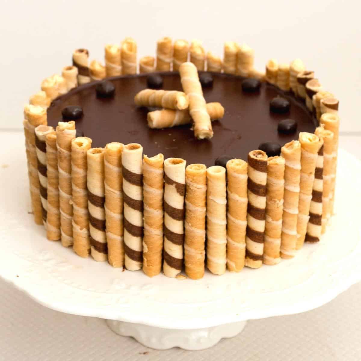 A flourless chocolate birthday cake with wafer cigars.