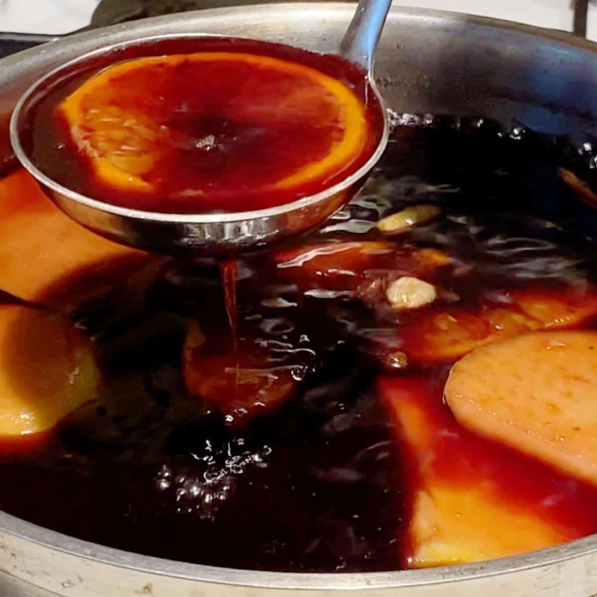 A saucepan with red wine mulled in spices.