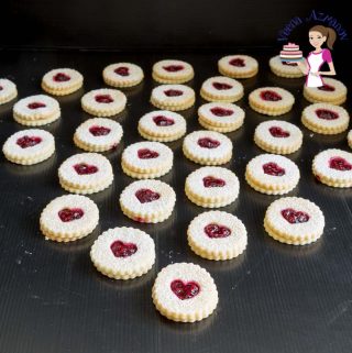 Raspberry Linzer cookies arranged on a table.