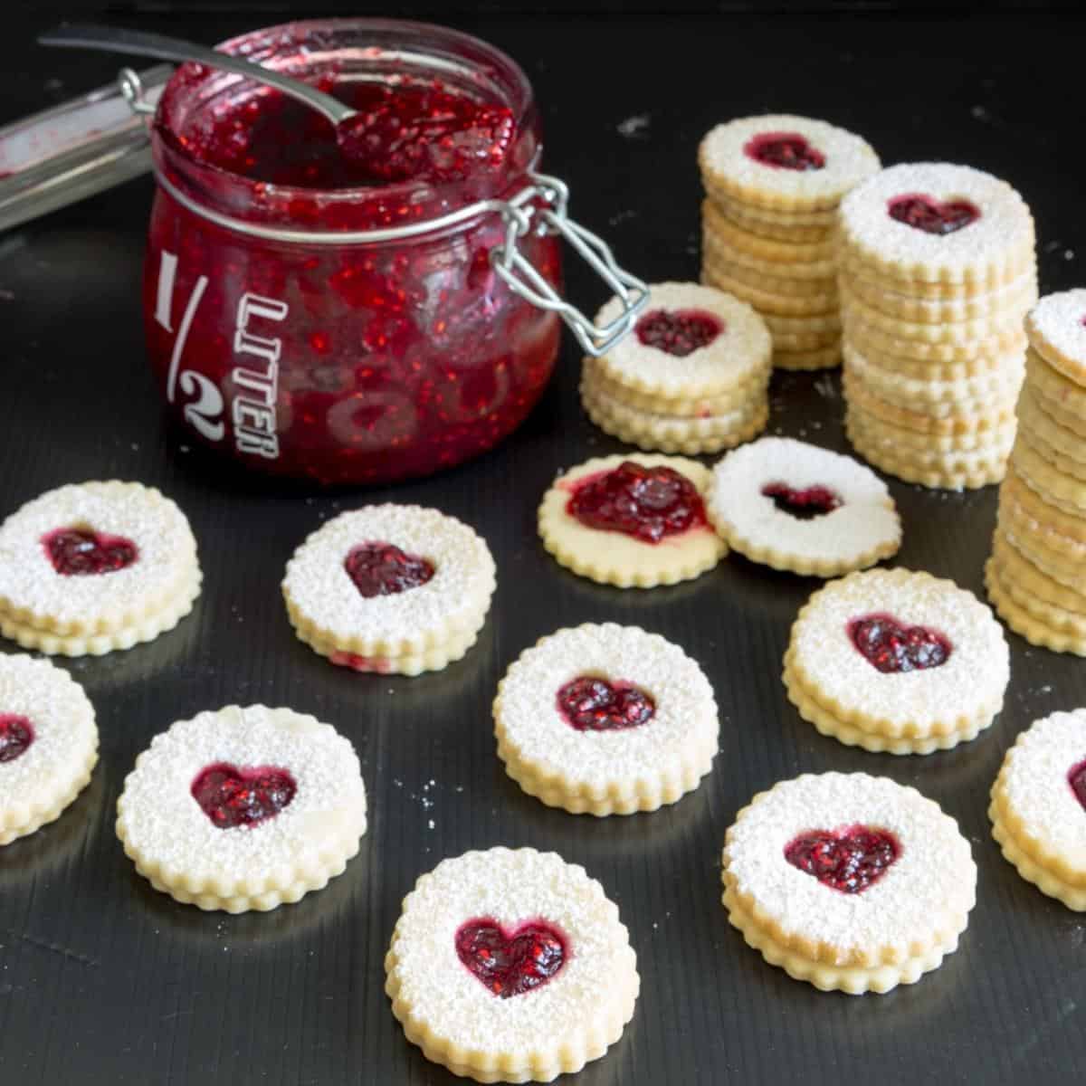 Sandwich cookies with raspberry jam on a wooden board