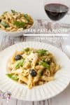 A plate of pasta with chicken and black olives.