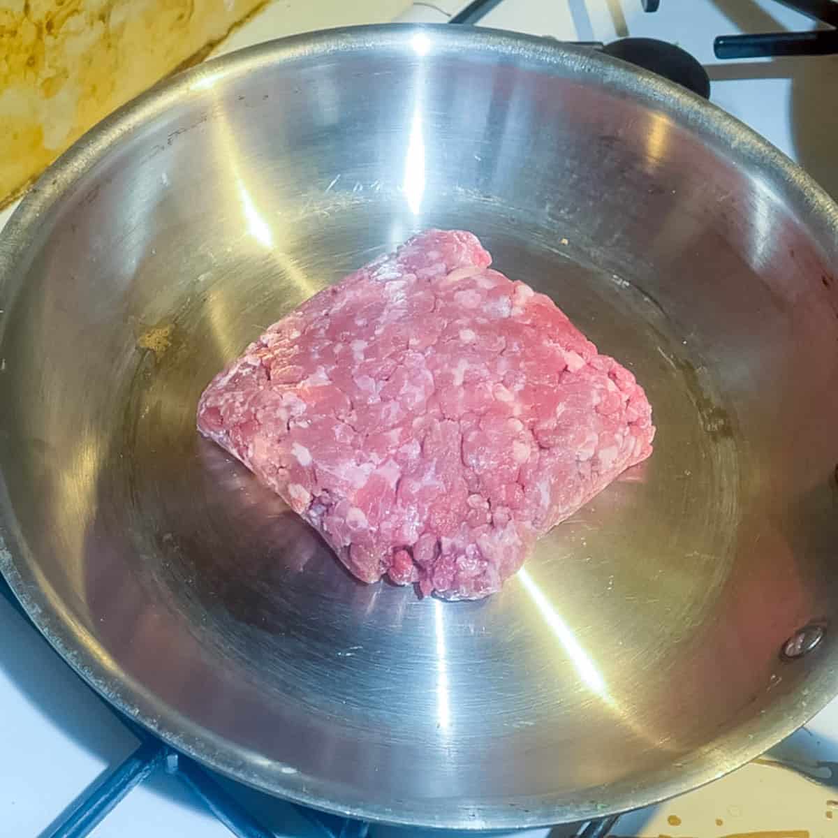 Browning the ground beef in a skillet.