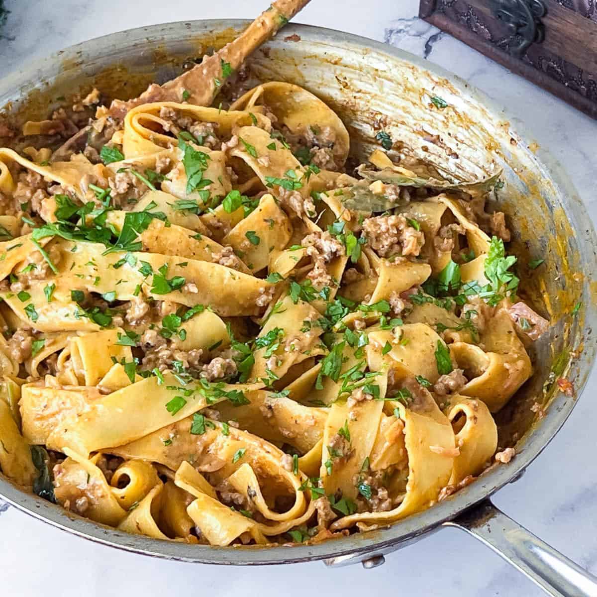 A skillet with ground beef sauce and pasta.