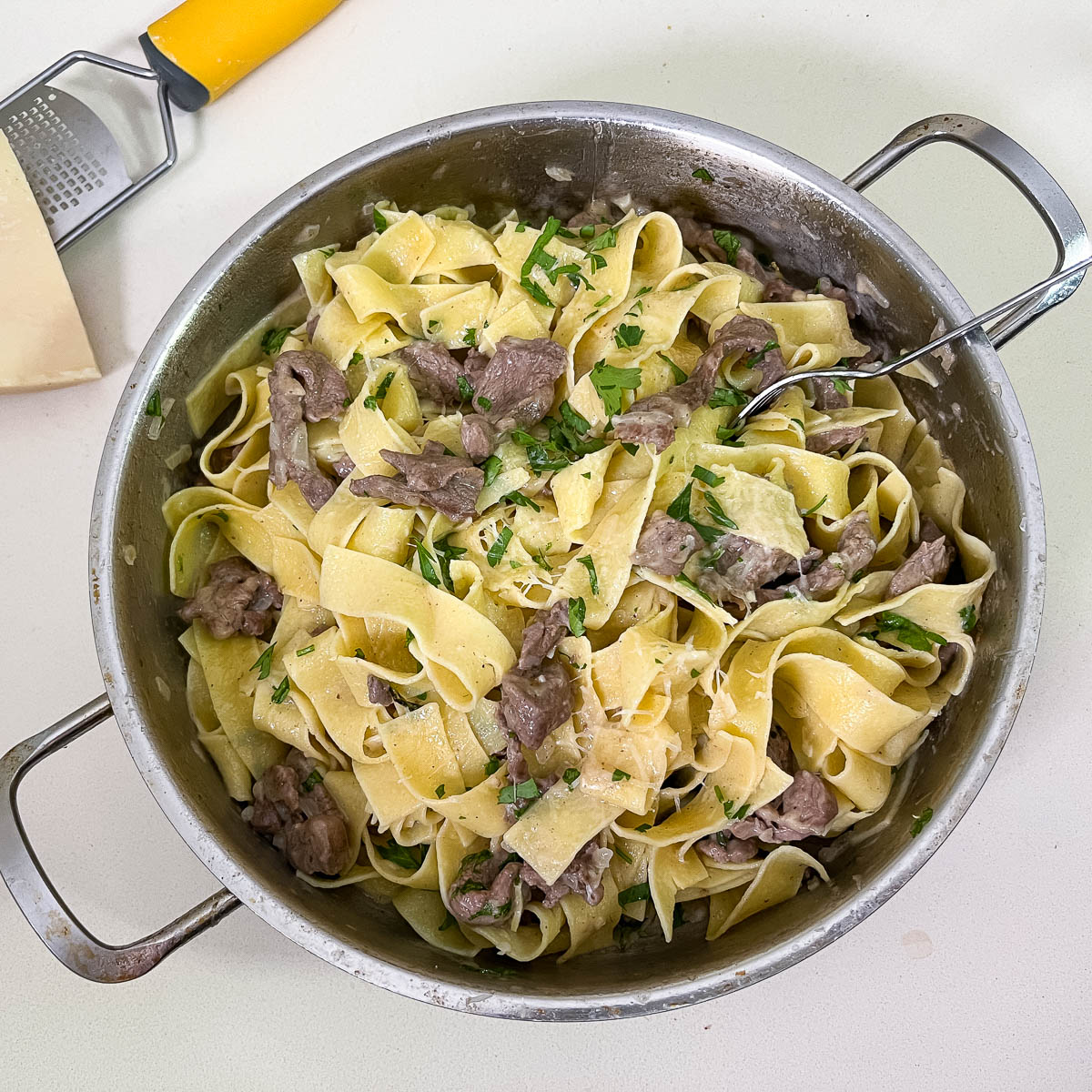 A saute pan with cooked pasta.