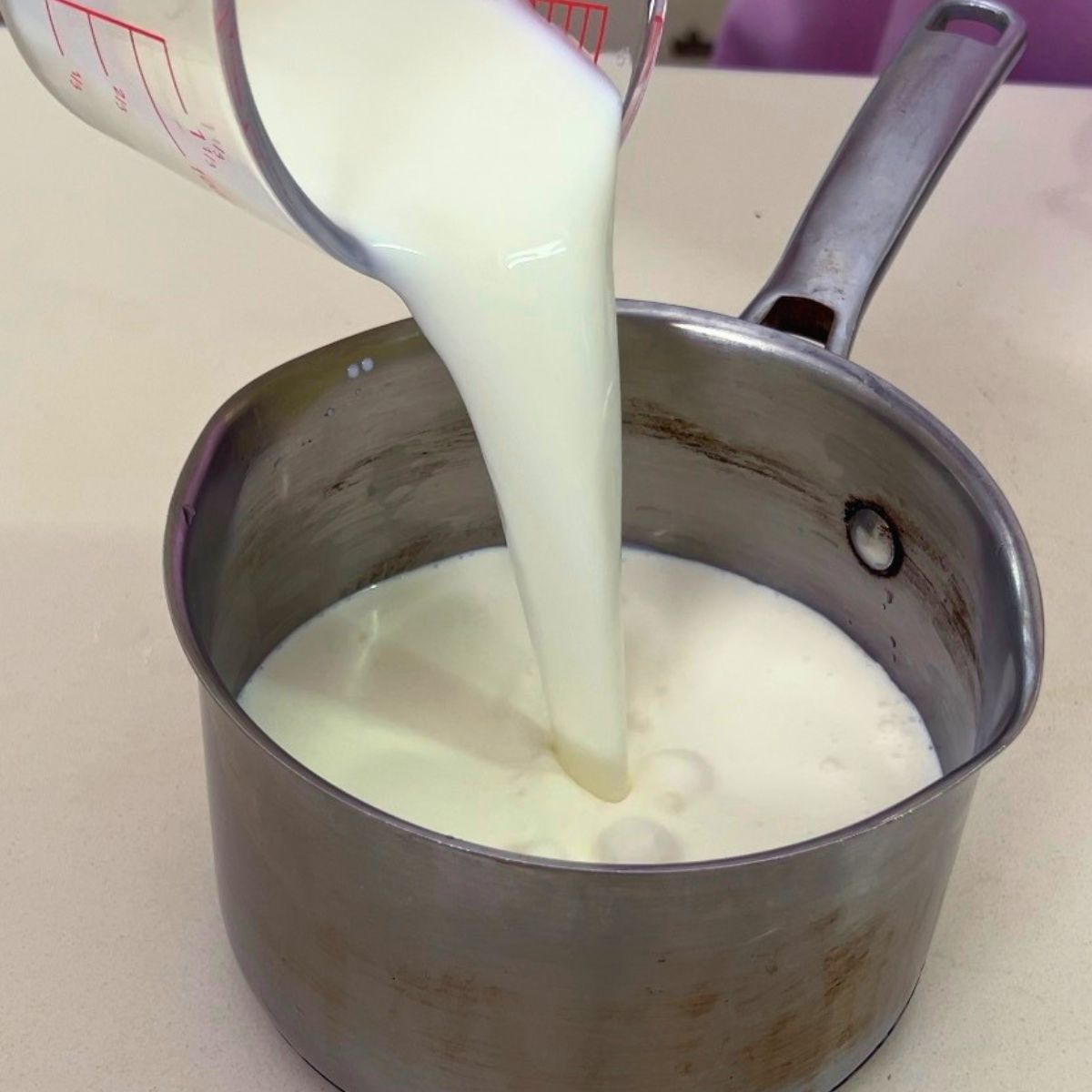 A saucepan with heavy cream and milk.