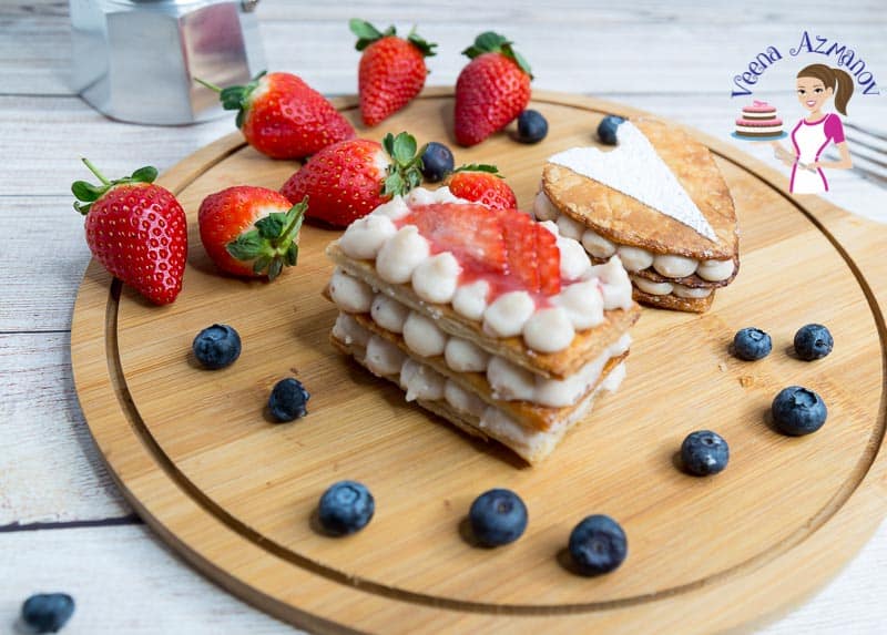 A piece of strawberry Mille-feuille on a wooden tray.