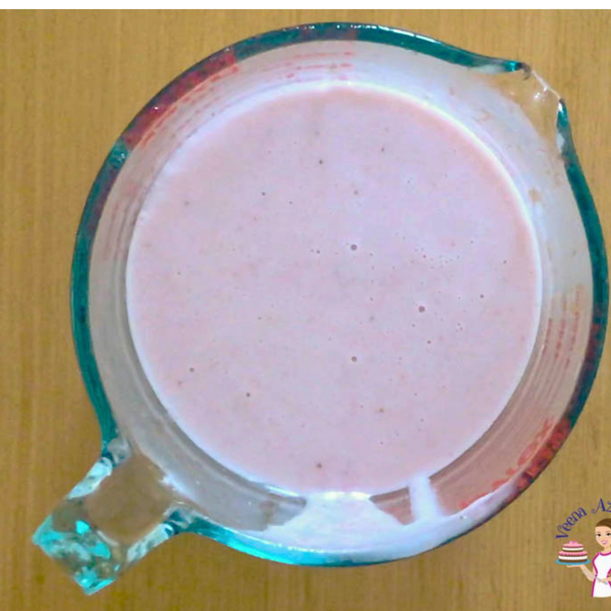 A measuring cup with strawberry panna cotta mixture.