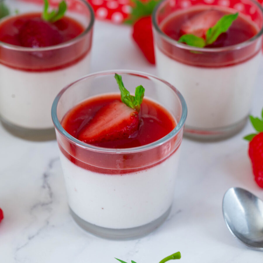 Mini cups with panna cotta and strawberry sauce.