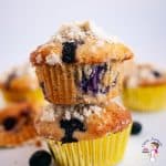 Two blueberry muffins, one on top of the other.