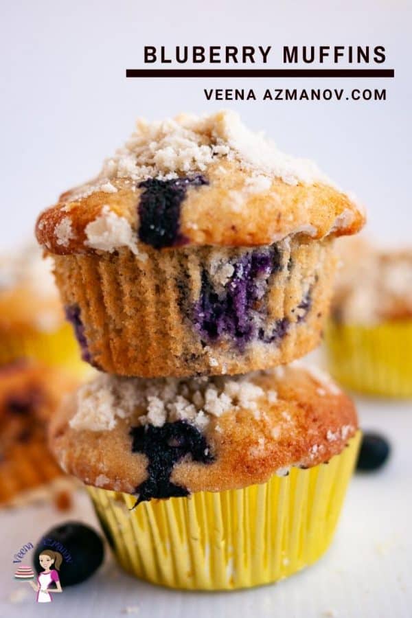 A close up of two blueberry muffins, one on top of the other.