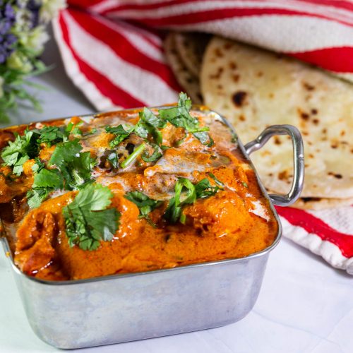 Butter chicken in an Indian serving dish.