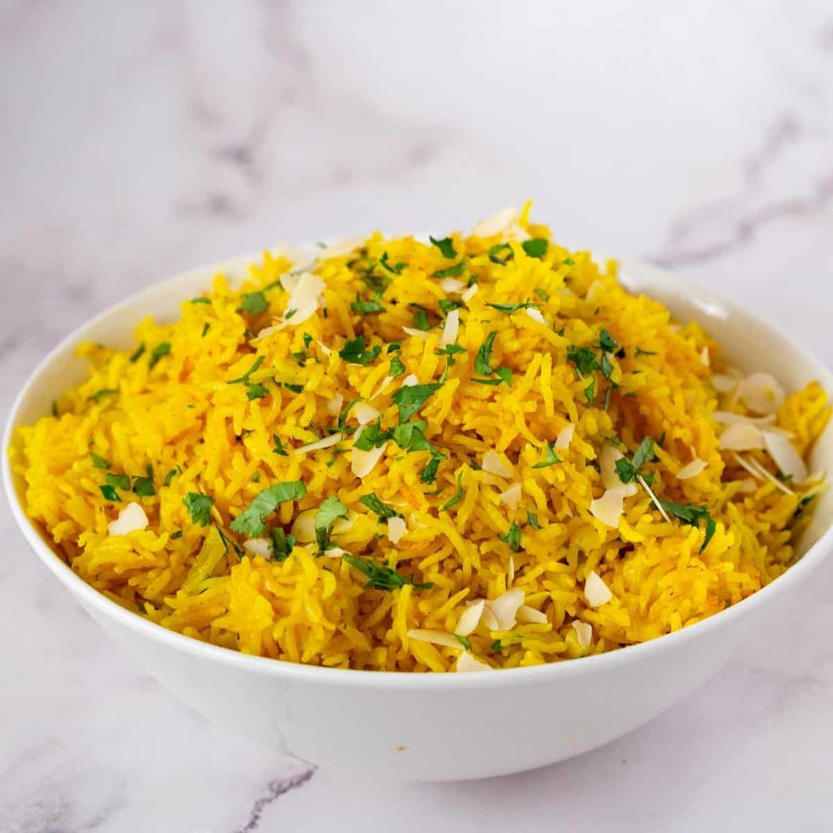 A bowl with yellow rice made with turmeric and coconut milk.