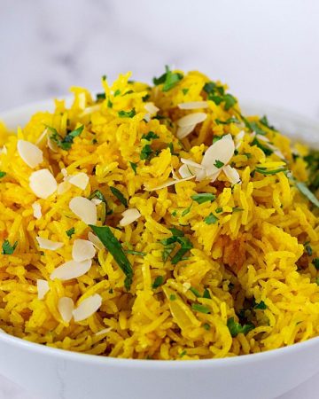 A white bowl with turmeric yellow rice.