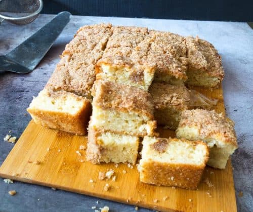 Coffee cake squares stacked on a wooden board.