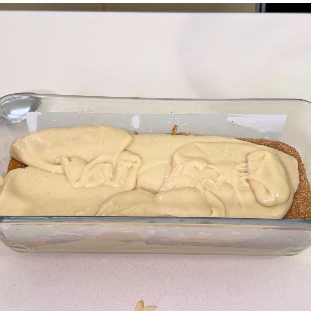 A loaf pan with cake batter crumble.
