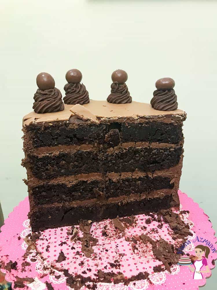 A sliced chocolate cake on a cake board.