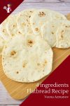 A close up of flatbread stacked on a wooden tray.
