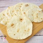 Flatbread stacked on a wooden tray.
