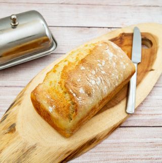A sandwich bread on a wooden board.