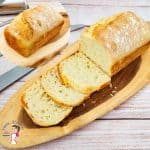 A sliced sandwich bread on a wooden board.