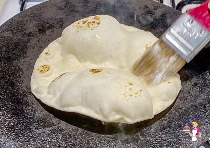 Flatbread being baked on a stovetop.