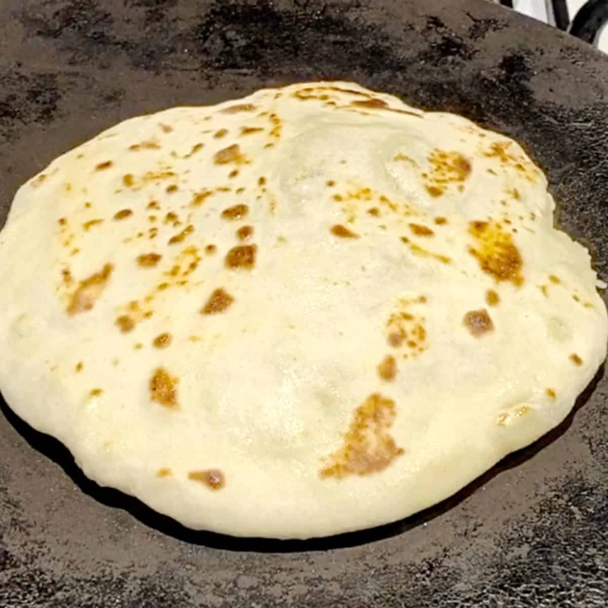 A skillet with flatbread.
