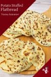 A close up of potato flatbread stacked on a wooden tray.