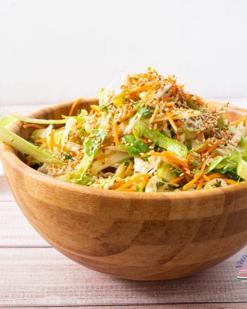 A bowl of Asian salad on a table.