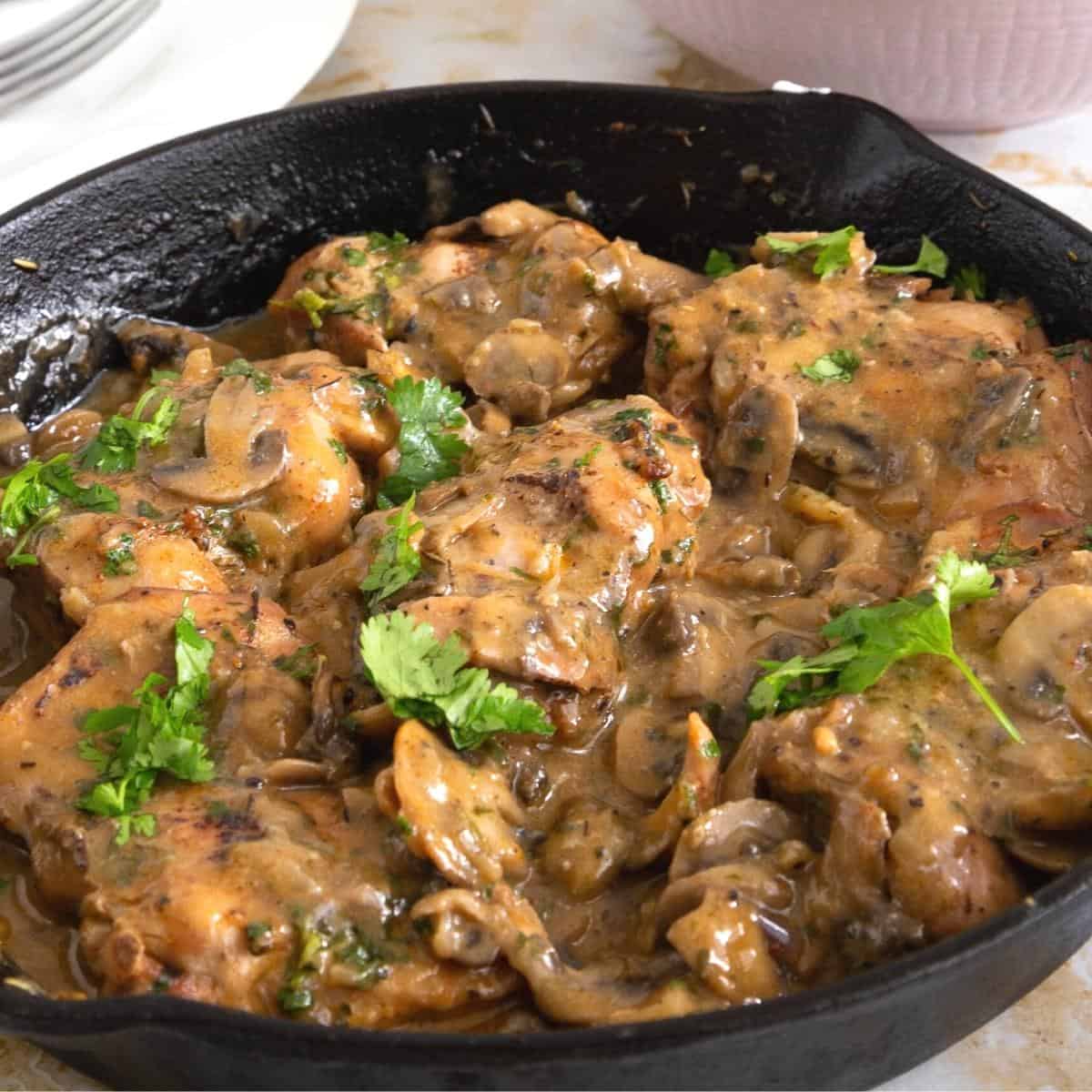Skillet with mushrooms in sauce.