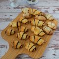 Several Chocolate rugelach pastry on a wooden tray.