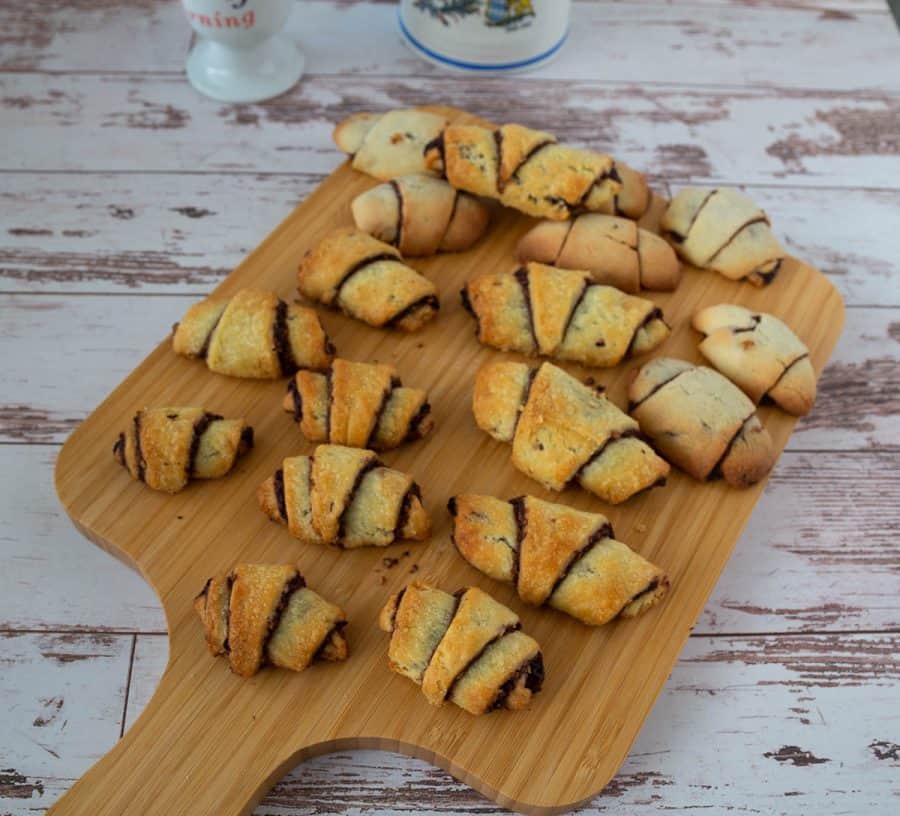 Several Chocolate rugelach pastry on a wooden tray.