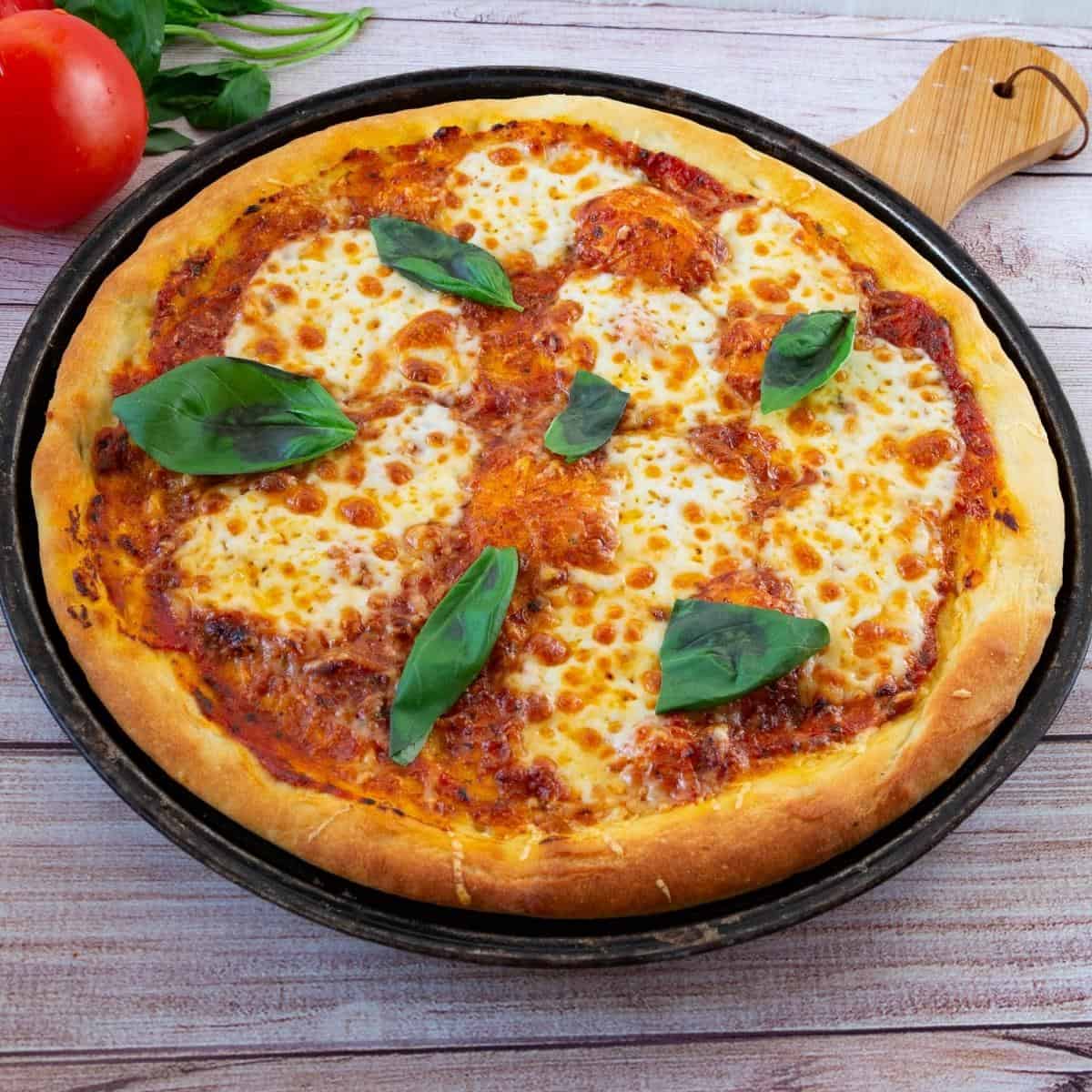 A fresh baked pizza on the pizza pan.