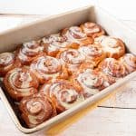 A baking pan with glazed cinnamon bread rolls.