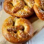 A wooden board with sesame pretzels.