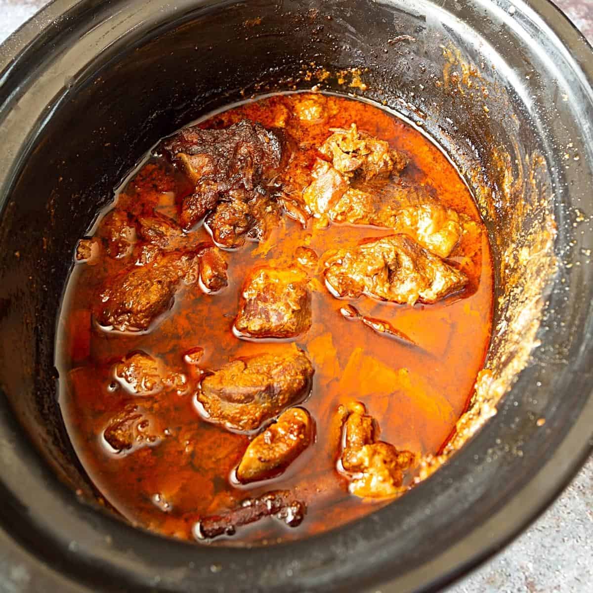 A slow cooker with curry made with goat meat.