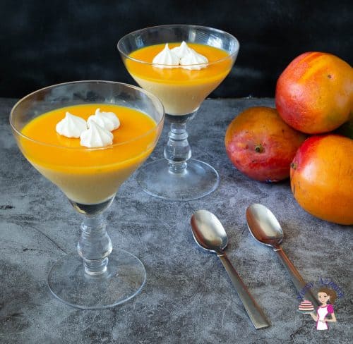 Two glasses with mango Panna cotta on a table.