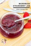 Strawberry jam in a jar with a spoon.