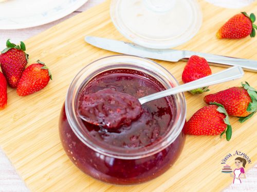 Strawberry jam in a jar with a spoon.