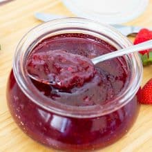Strawberry jam in a jar with spoon.