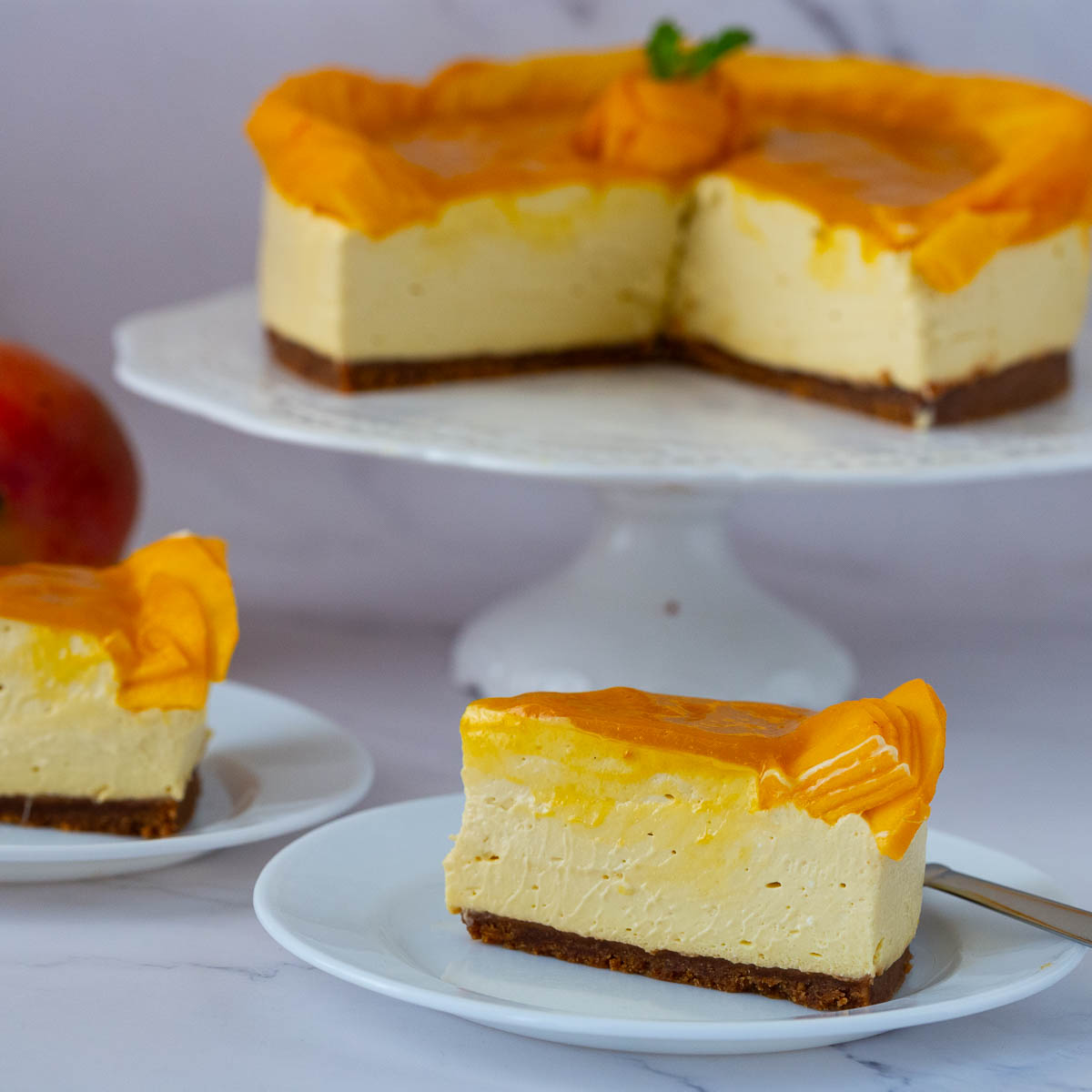 Sliced no bake mango cheesecake on the table.