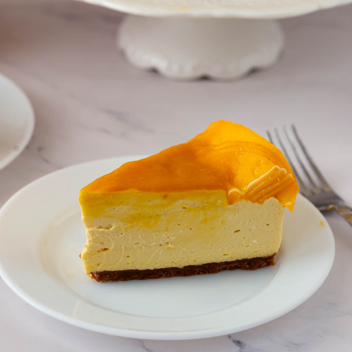A slice of no bake mango cheesecake on the table.