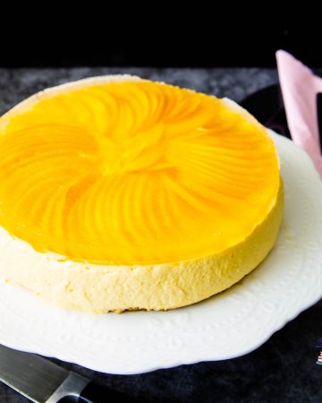 Mango cheesecake on a cake stand.