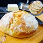 A loaf of round bread on a wooden board.