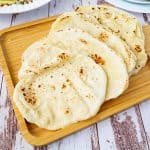 A wooden board with flatbreads.