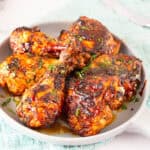 A serving platter with cajun spiced chicken thighs and legs.