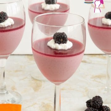 A wine glass filled with blackberry Panna Cotta.