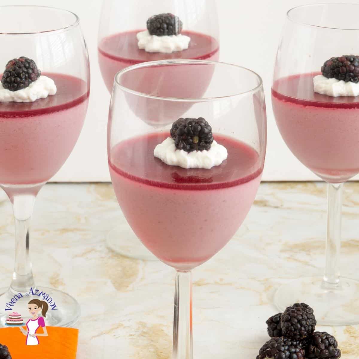 4 wine glasses filled with blackberry Panna Cotta.