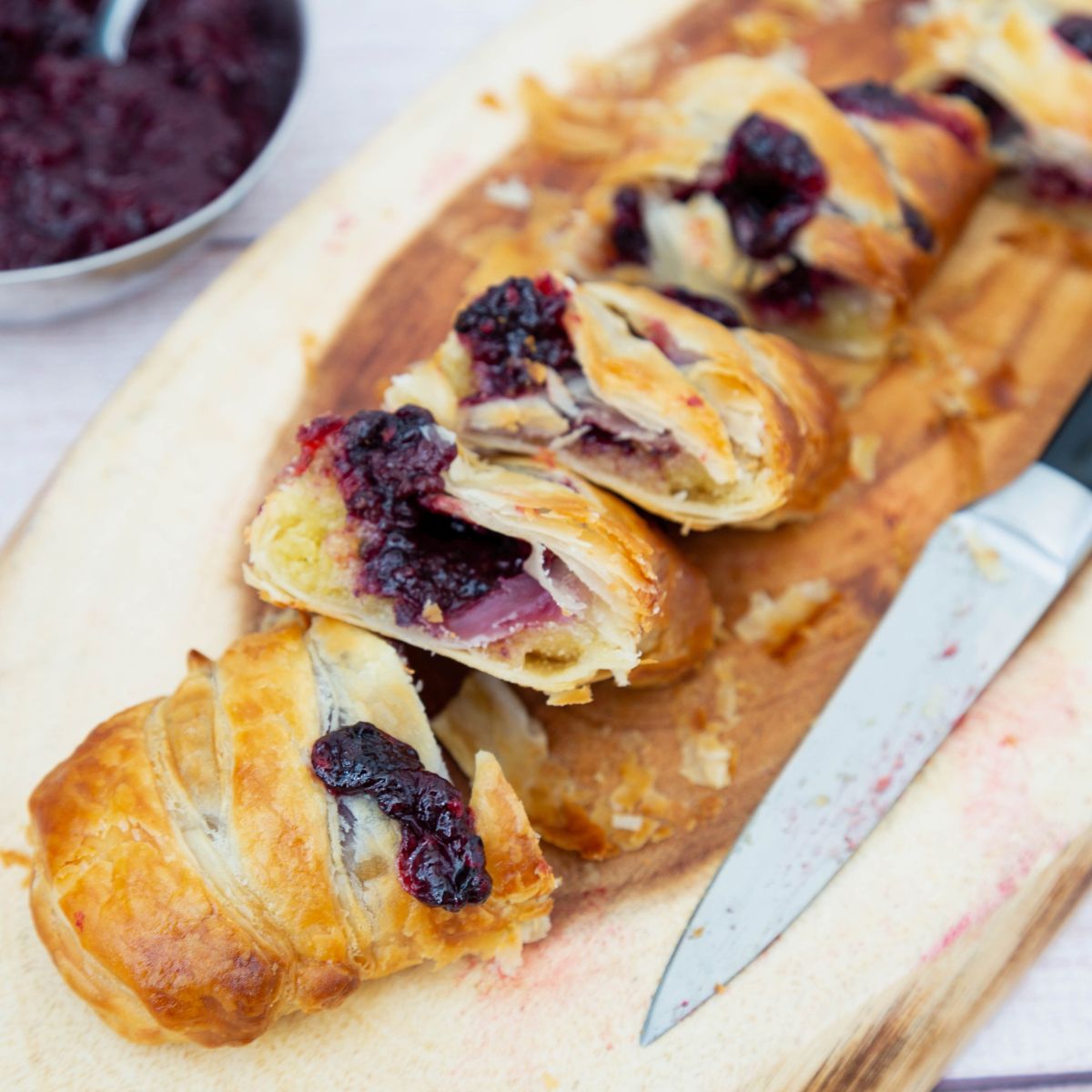 A wooden board with cut braided pastry.