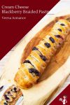 A braided pastry with blackberries on a wooden tray.